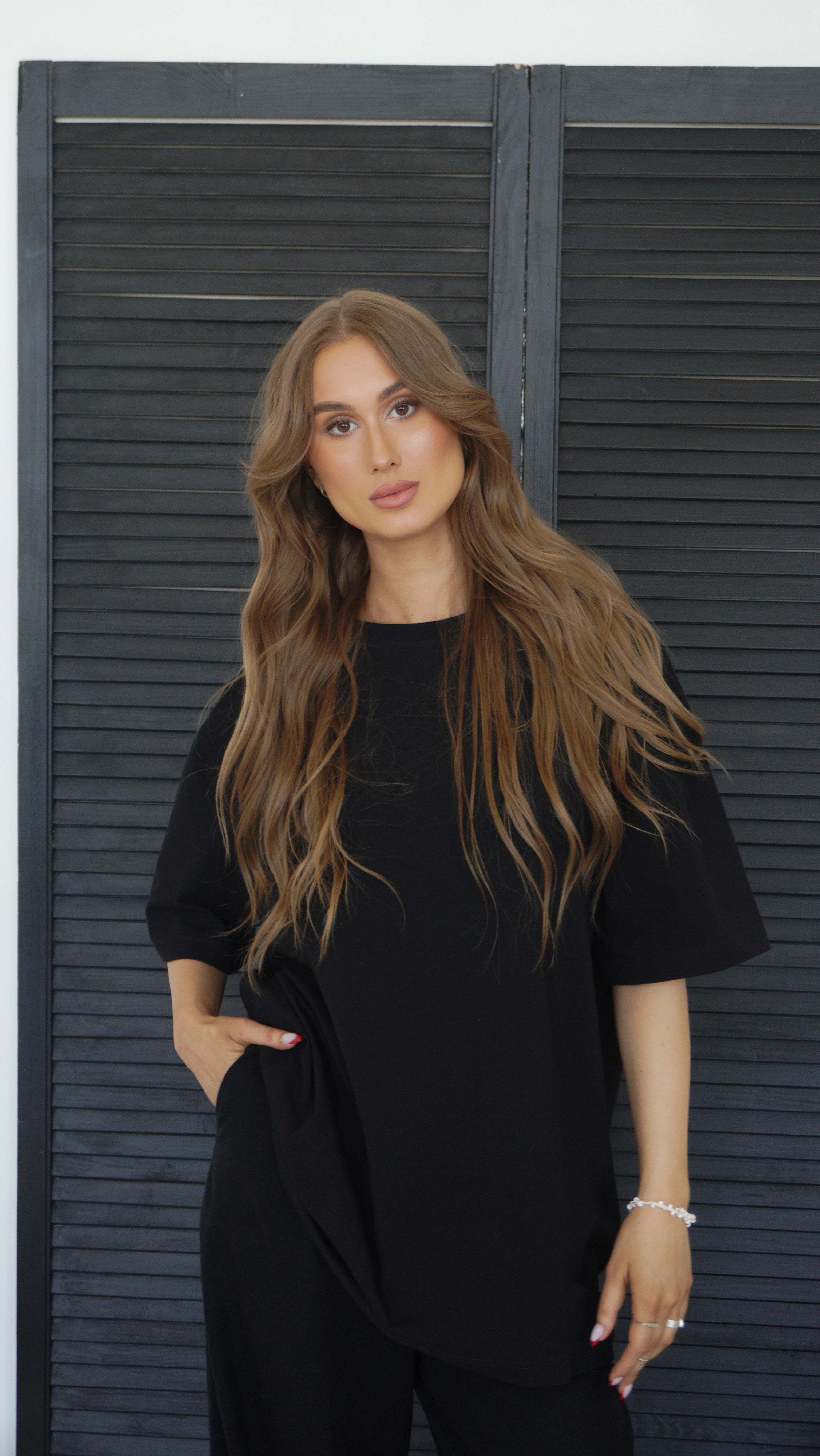 Die Frau trägt ein schwarzes, übergroßes Damen-T-Shirt