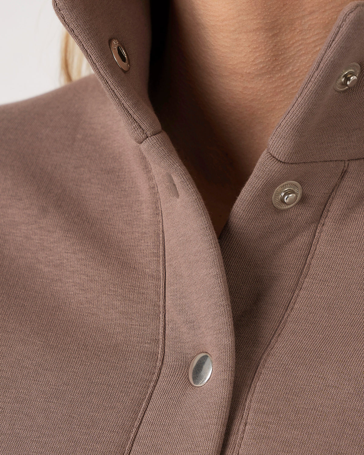 Ein warmer Freizeitanzug mit Knöpfen und geraden Hosenbeinen in gebleichter Kakaofarbe