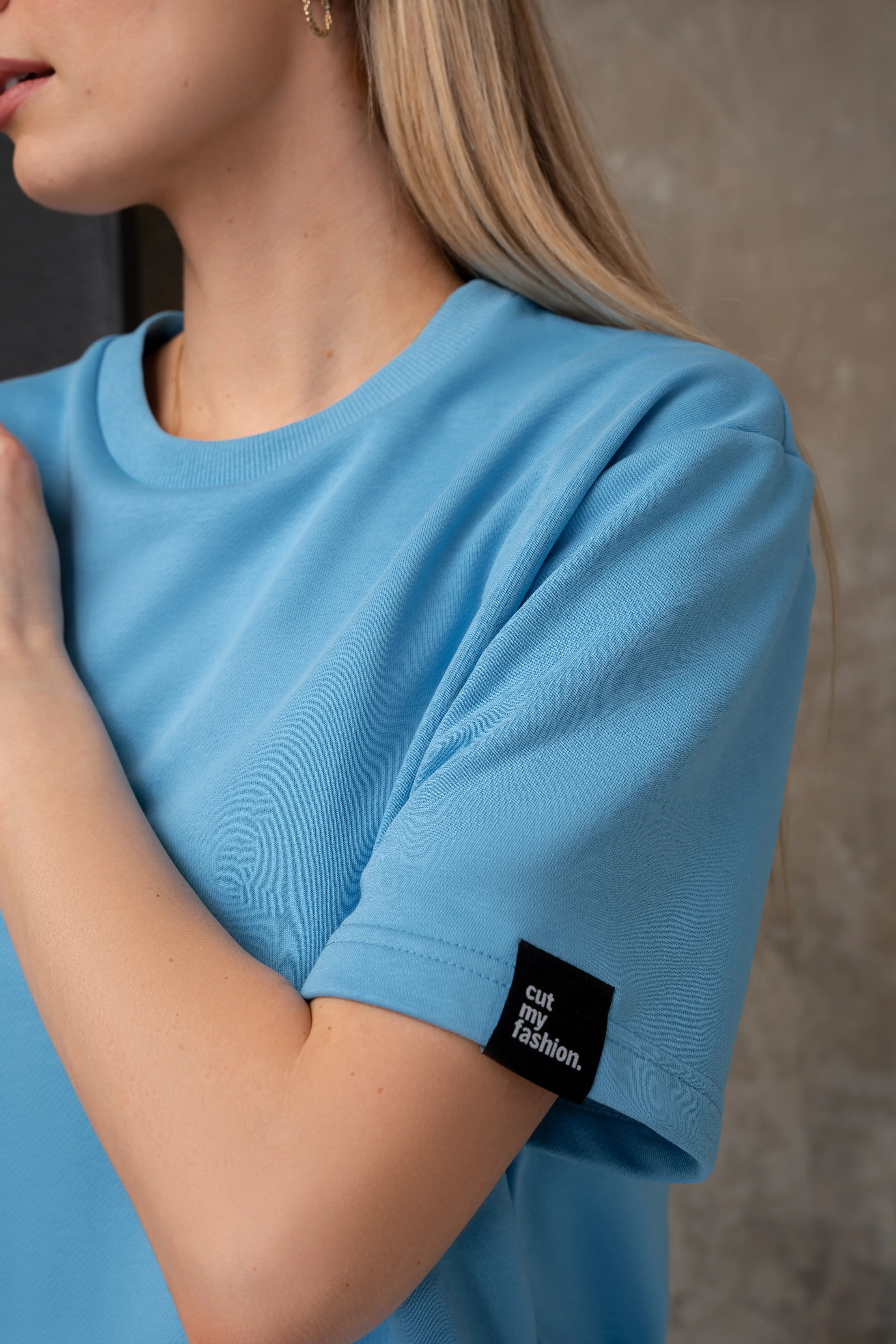 Detail an den Ärmeln der blauen Bluse mit dem „cutmyfashion“-Logo