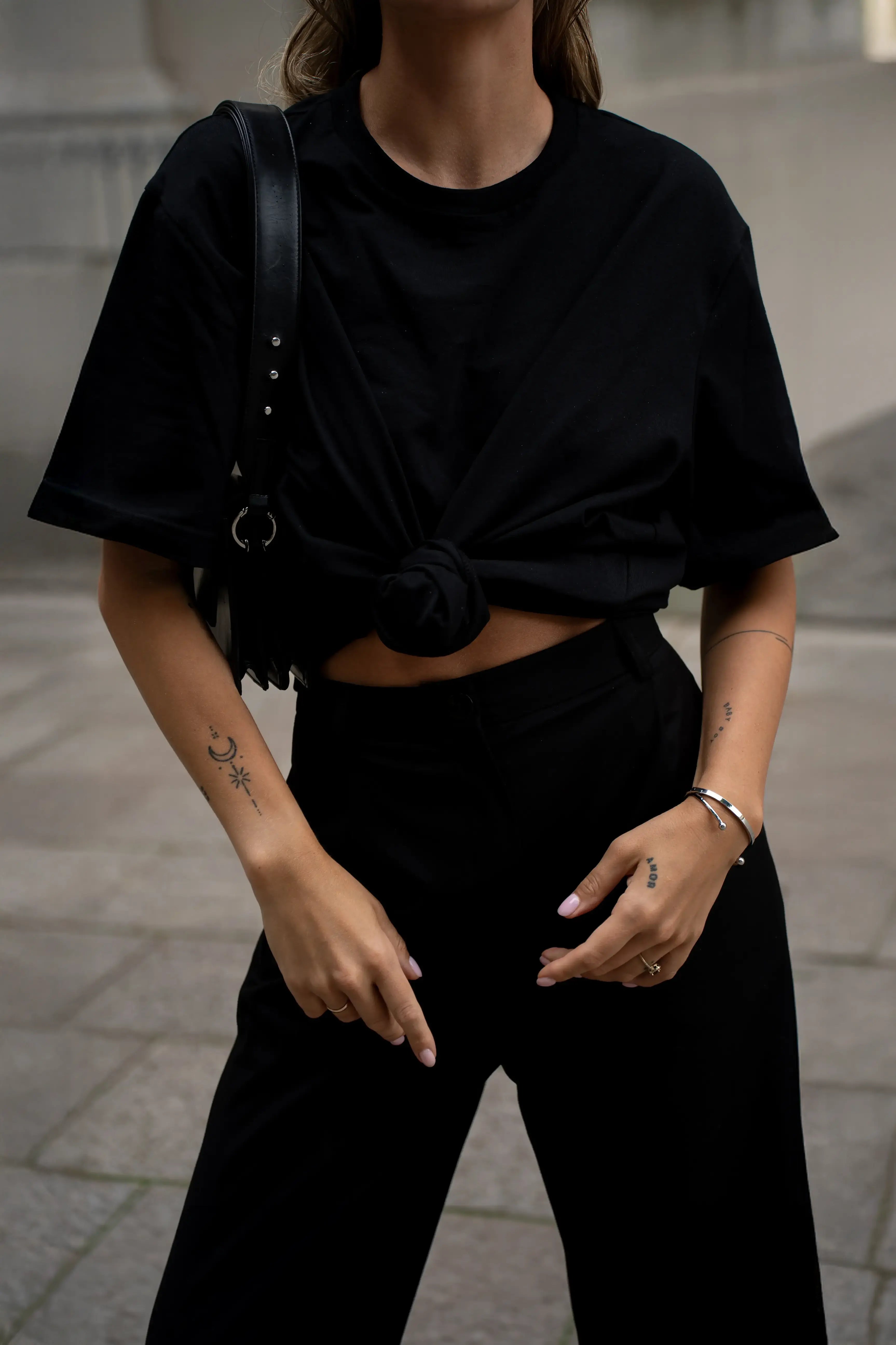 Ein schwarzes Oversize-T-Shirt mit dem Cutmyfashion-Logo und eine schwarze Hose mit Taschen