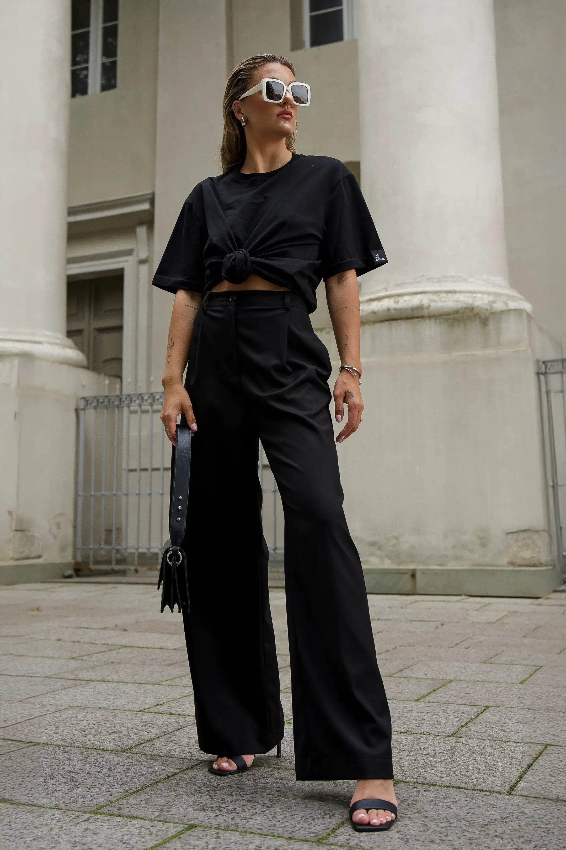 Ein Outfit für Damen bestehend aus einem schwarzen Oversize-T-Shirt und einer schwarzen klassischen Hose