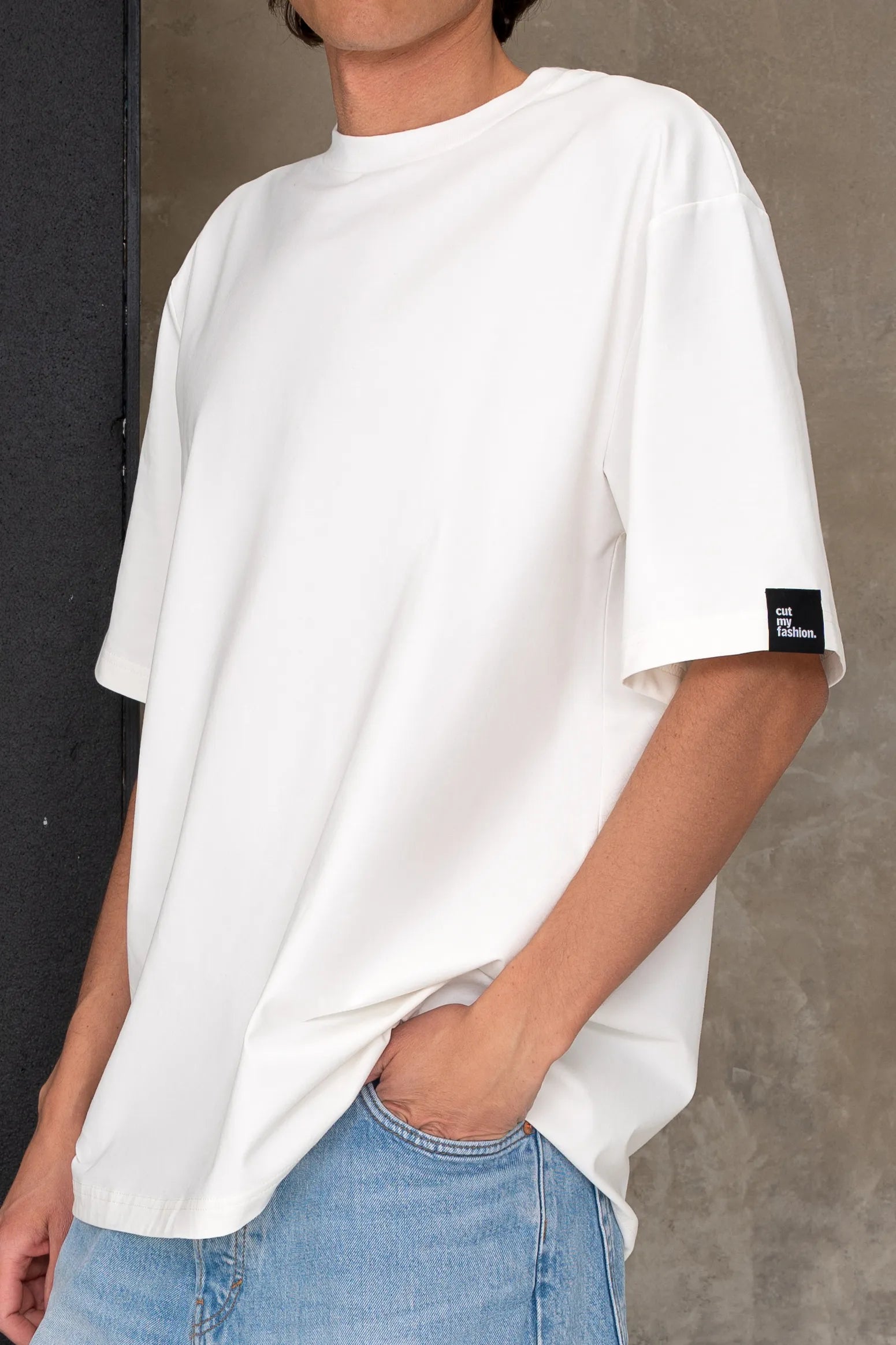 Balti vyriški oversized marškinėliai trumpomis rankovėmis su juoda cutmyfashion etikete ant rankovės