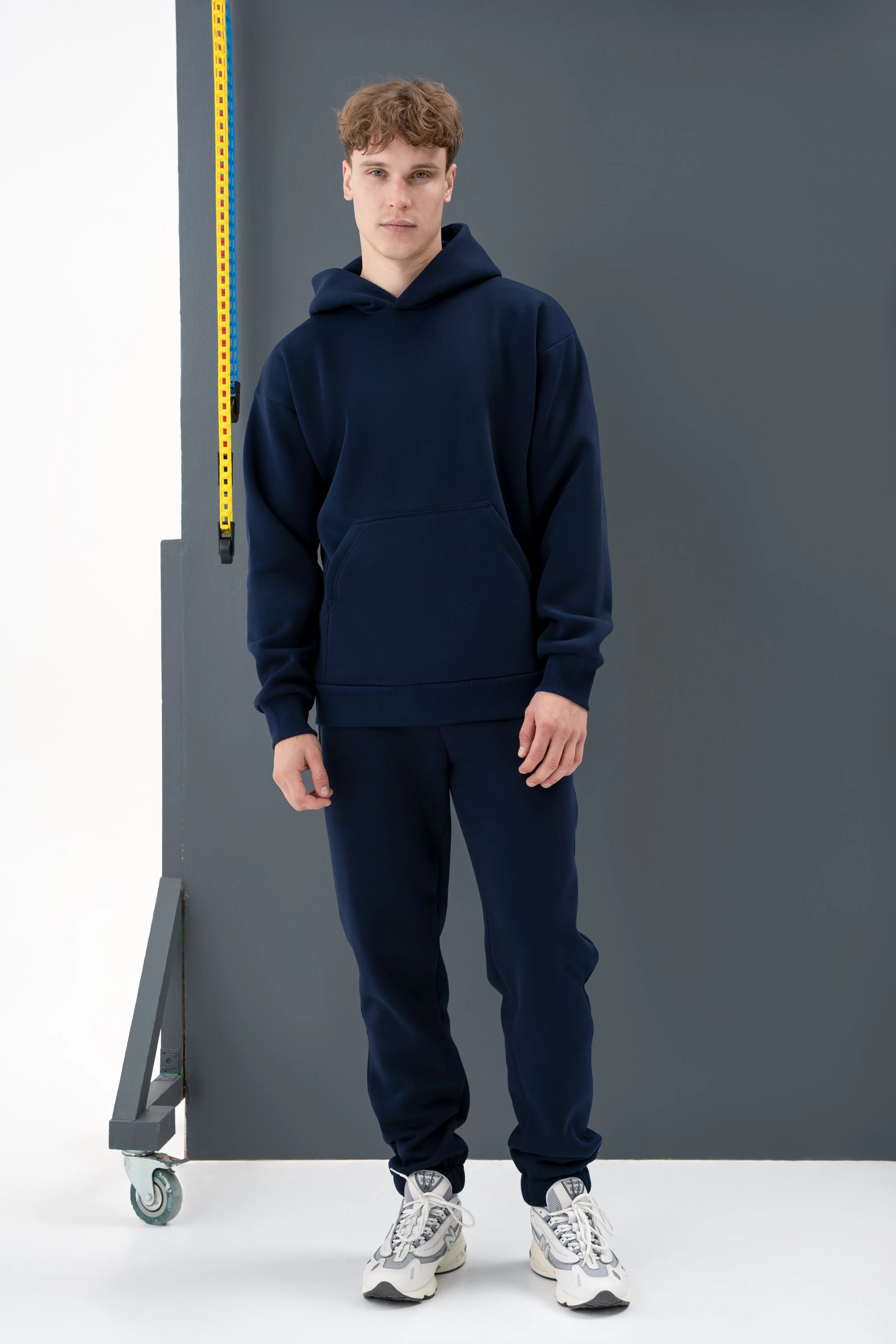 Tamsiai mėlynas vyriškas laisvalaikio treningas su kapišonu, pagamintas cutmyfashion siuvykloje Lietuvoje.