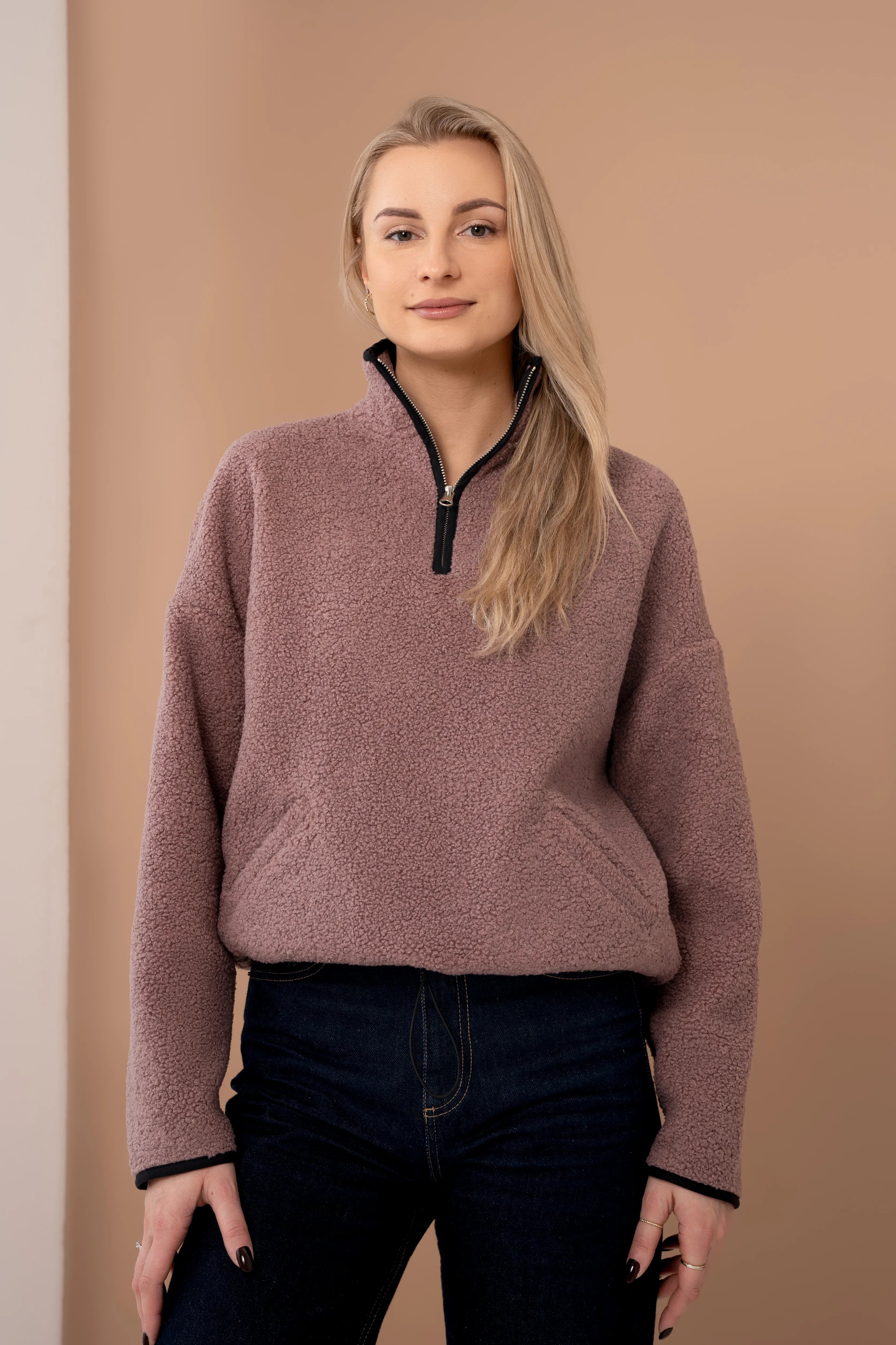 Rausvos spalvos moteriškas džemperis su trumpu užtrauktuku, stačia apykakle, ilgomis rankovėmis ir kišenėmis priekyje
