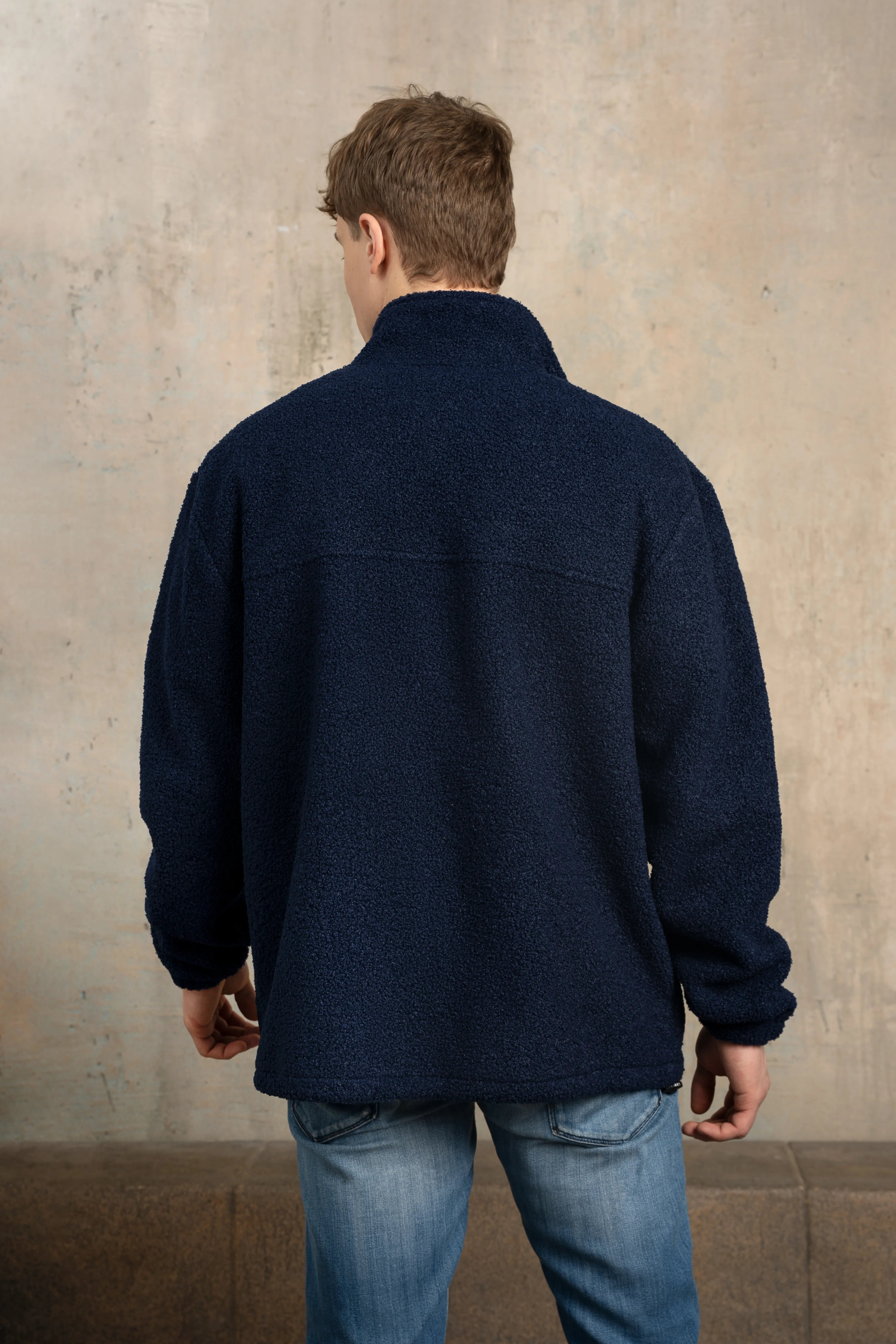 Dunkelblauer Herrenpullover, von hinten gesehen mit Stehkragen, langen Ärmeln und geradem Rücken