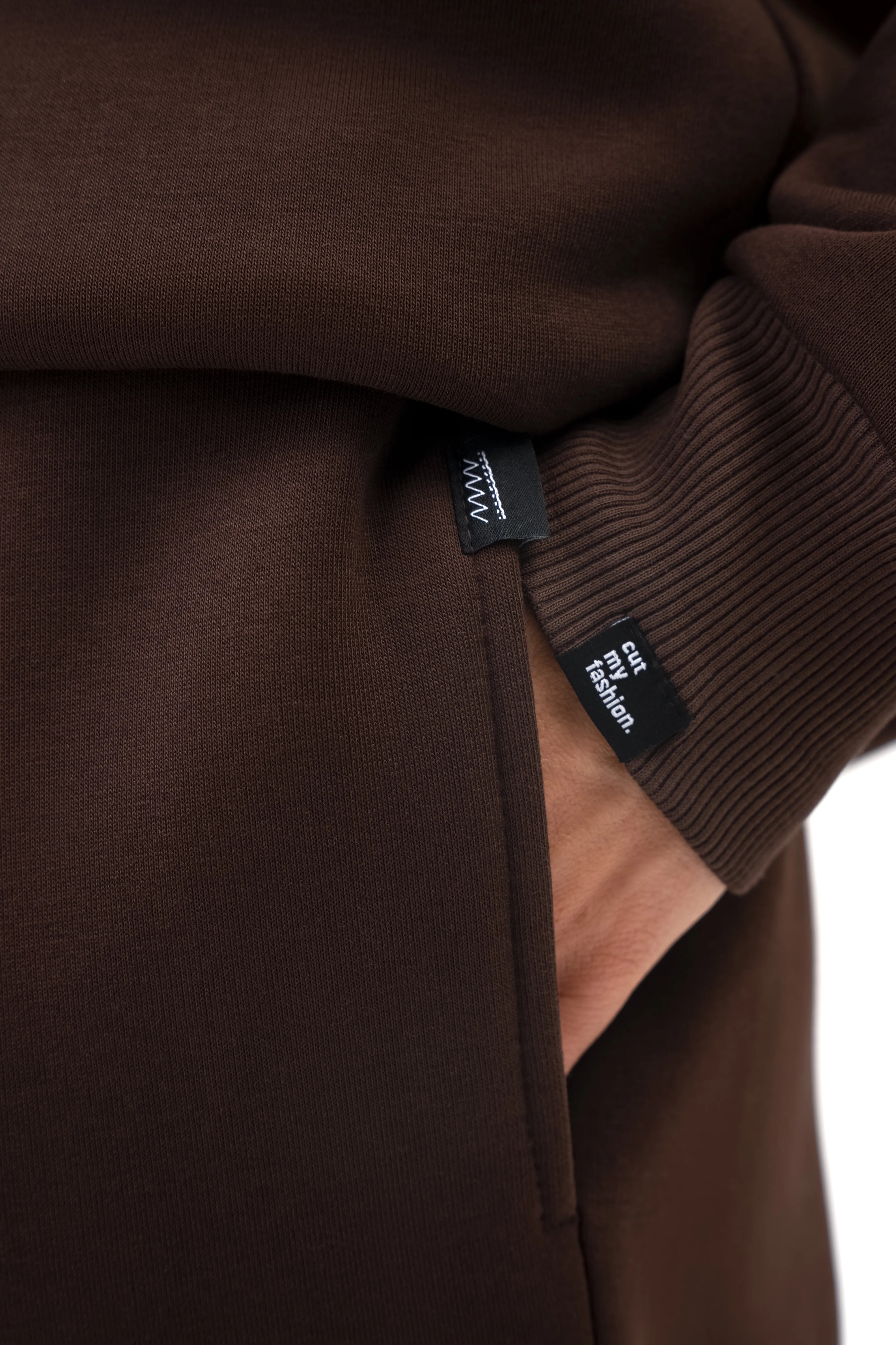 Rudo vyriško laisvalaikio kostiumėlio kišenės ir rankogalio detalė su minimalistine cutmyfashion etikete