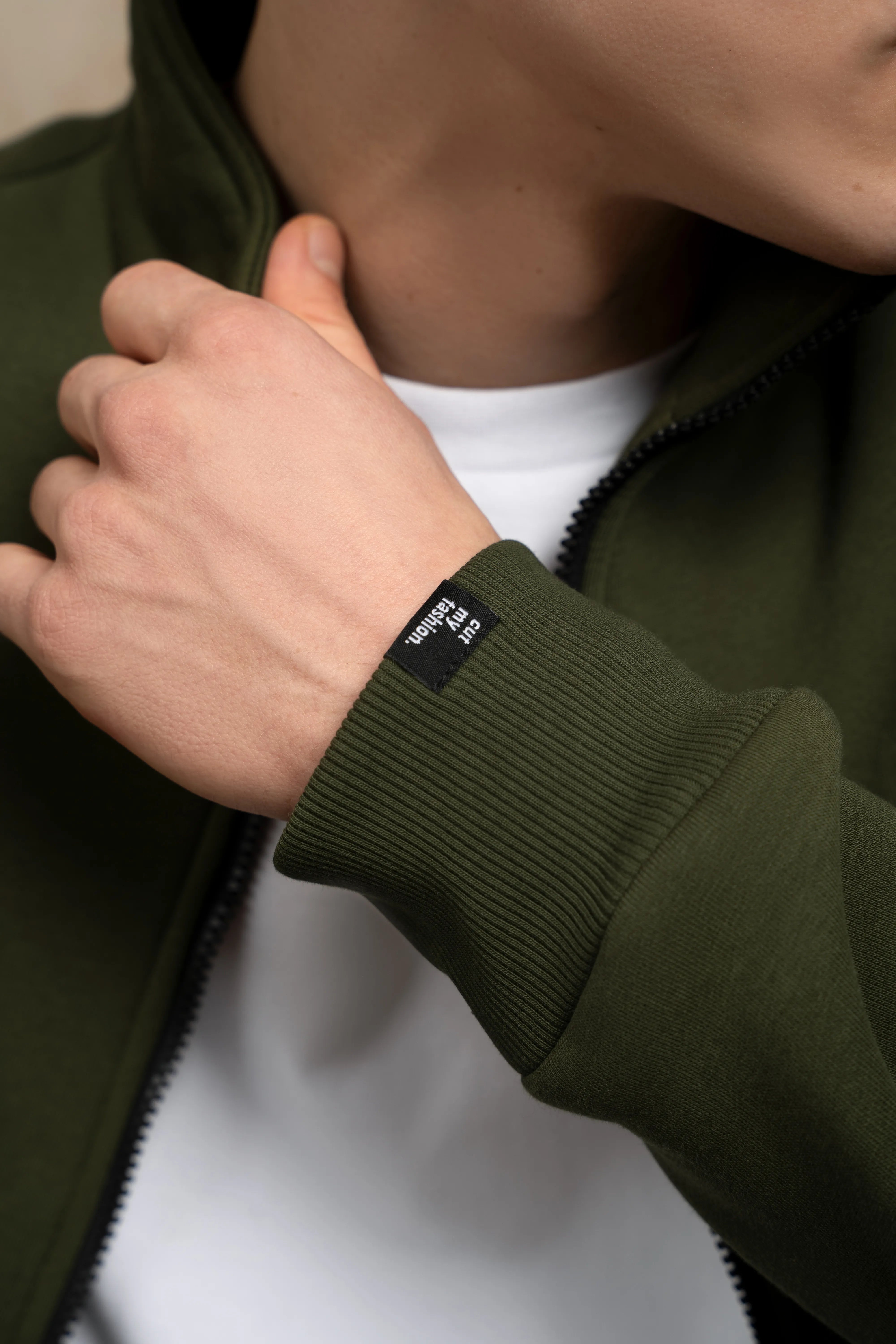 Tamsiai žalio treningo rankogalis su detale, skirtas patogiam laisvalaikiui ir poilsiui.