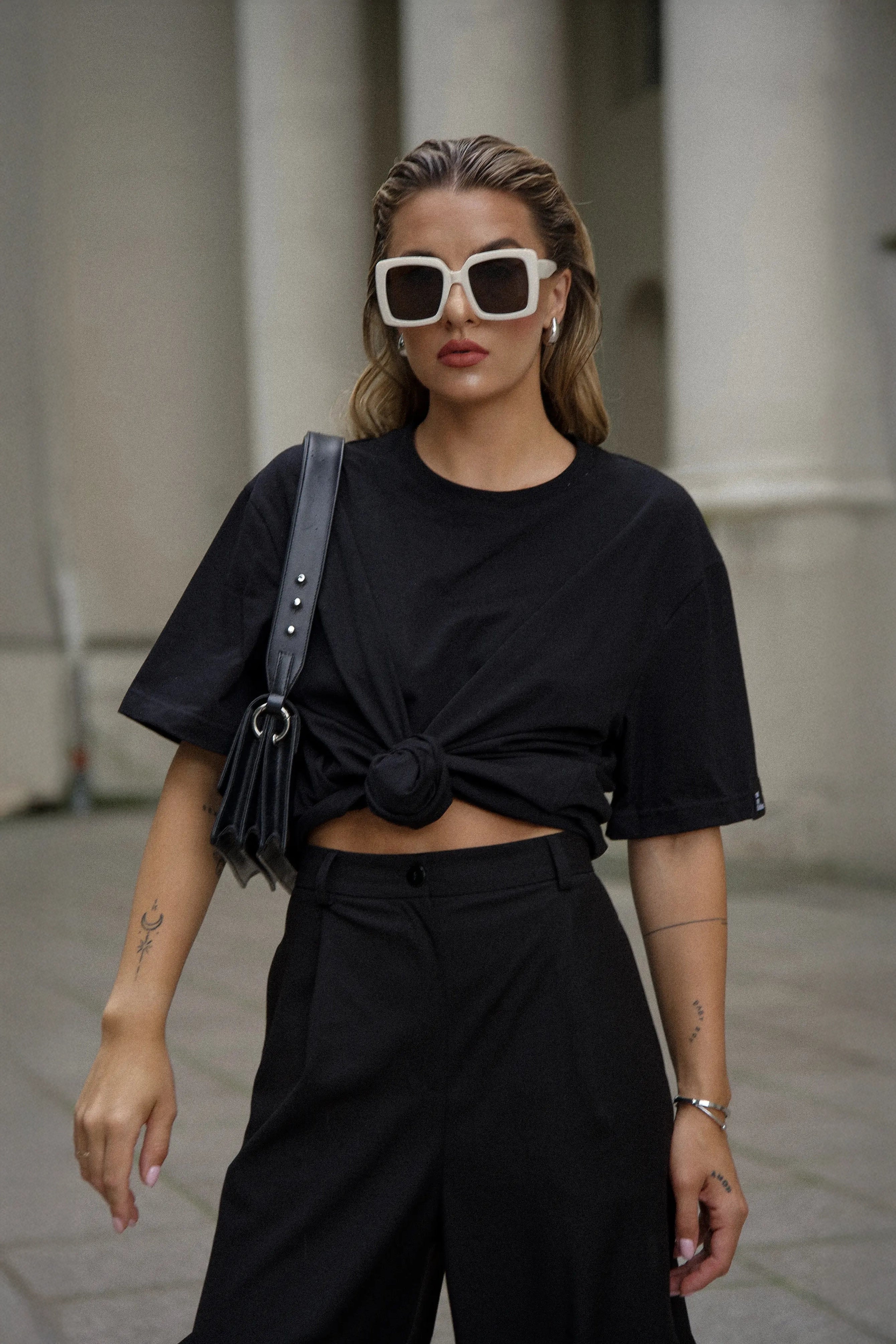 Ein feminines Outfit mit einem schwarzen Oversize-T-Shirt und einer schwarzen klassischen Hose